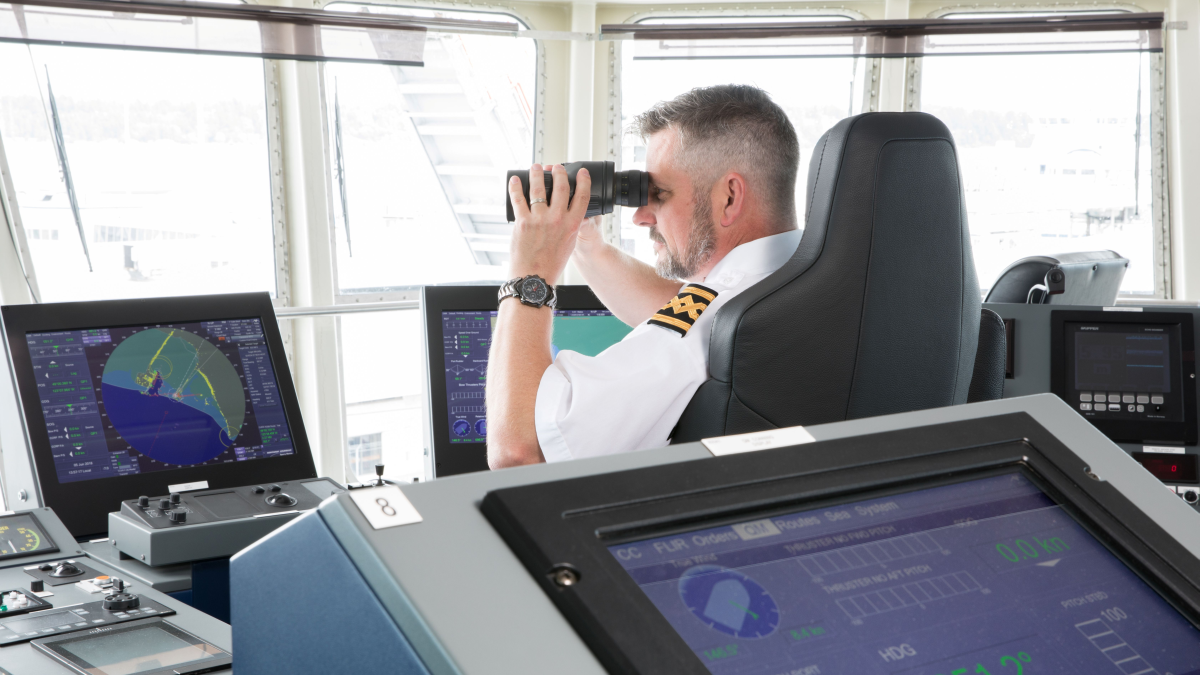 An officer on a commercial ship is verifying vessel position after being alerted to potential GNSS jamming