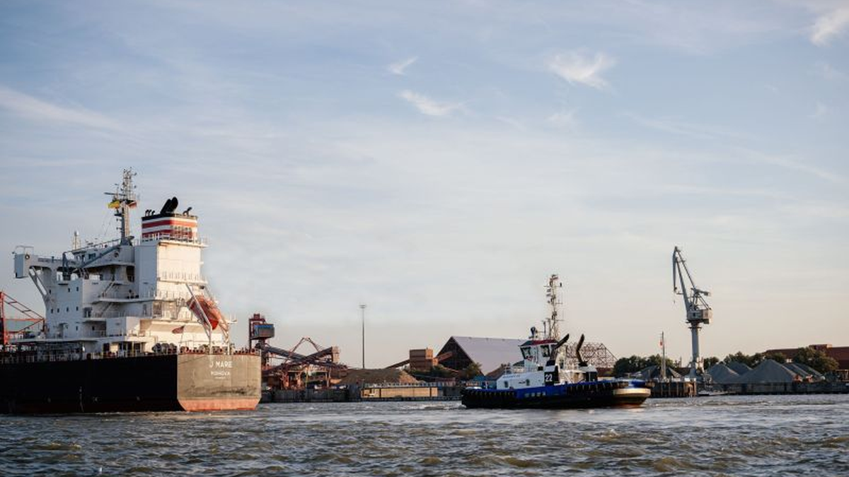 A Fairplay tug supports a ship in Elbe estuary